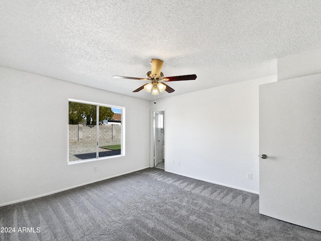 carpeted empty room with ceiling fan and a textured ceiling