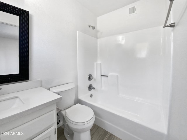 full bathroom with shower / bathing tub combination, vanity, hardwood / wood-style flooring, and toilet