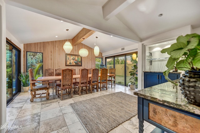 dining space featuring vaulted ceiling with beams and wood walls