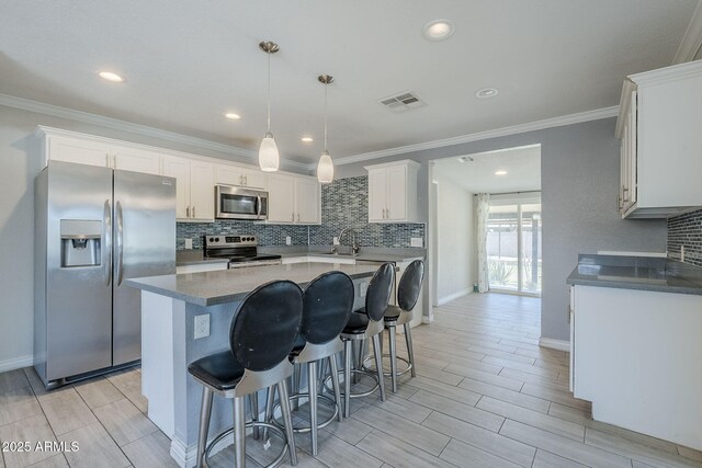 7135 W Flower St, Phoenix, AZ 85033 - kitchen featuring stainless steel appliances, a sink, backsplash, wood finish floors, and a breakfast bar area