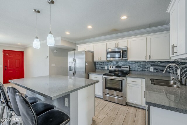 7135 W Flower St, Phoenix, AZ 85033 - kitchen with appliances with stainless steel finishes, a sink, ornamental molding, white cabinetry, and backsplash