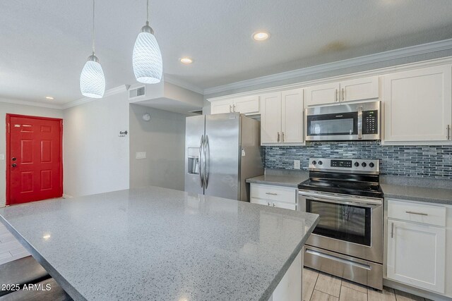 7135 W Flower St, Phoenix, AZ 85033 - kitchen featuring appliances with stainless steel finishes, ornamental molding, white cabinets, backsplash, and decorative light fixtures