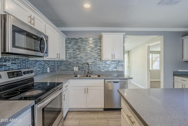 7135 W Flower St, Phoenix, AZ 85033 - kitchen featuring appliances with stainless steel finishes, a sink, tasteful backsplash, white cabinets, and ornamental molding