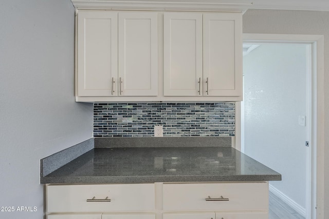 7135 W Flower St, Phoenix, AZ 85033 - kitchen featuring backsplash, white cabinetry, and dark stone counters