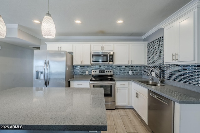 7135 W Flower St, Phoenix, AZ 85033 - kitchen featuring stainless steel appliances, a sink, ornamental molding, white cabinets, and hanging light fixtures