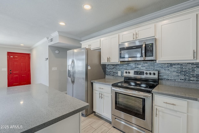 7135 W Flower St, Phoenix, AZ 85033 - kitchen featuring appliances with stainless steel finishes, ornamental molding, backsplash, white cabinets, and recessed lighting