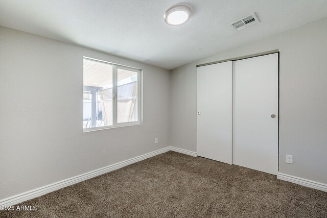 7135 W Flower St, Phoenix, AZ 85033 - unfurnished bedroom featuring dark colored carpet, a closet, and baseboards