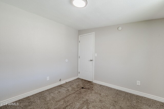 7135 W Flower St, Phoenix, AZ 85033 - empty room featuring carpet, baseboards, and a smoke detector