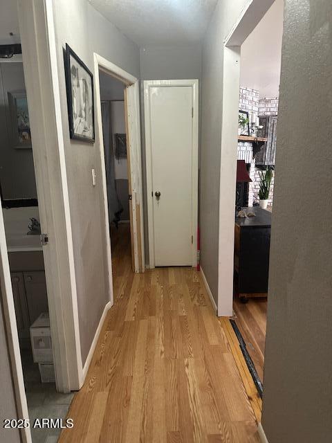 hall with light wood finished floors and baseboards