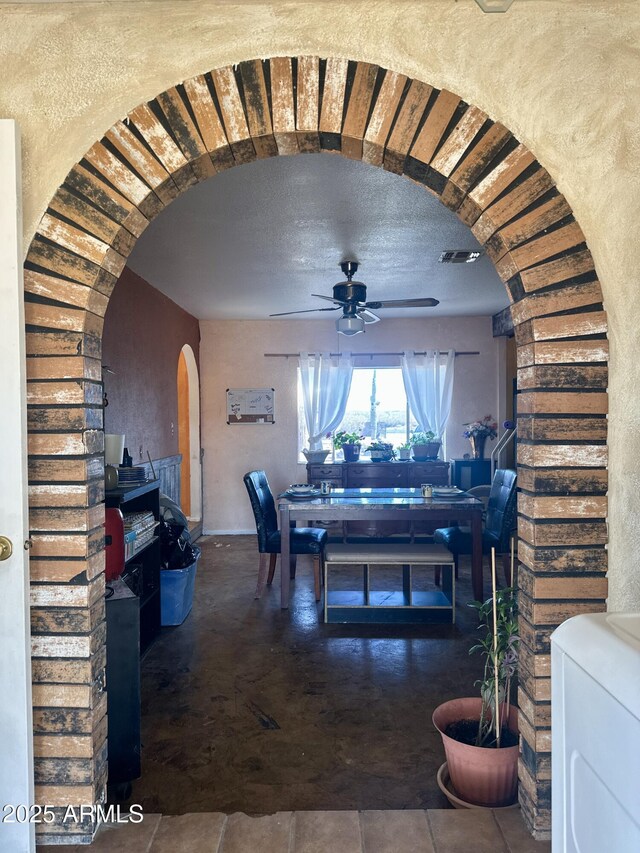 dining room with visible vents, arched walkways, a ceiling fan, washer / clothes dryer, and a textured ceiling