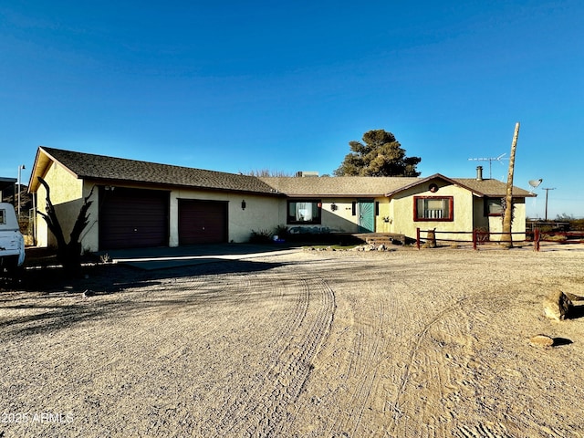 ranch-style home with driveway, an attached garage, and stucco siding