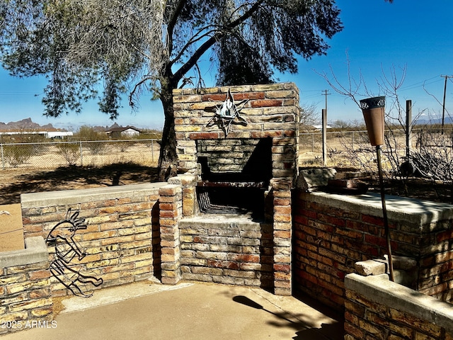 view of patio / terrace with a fireplace and fence