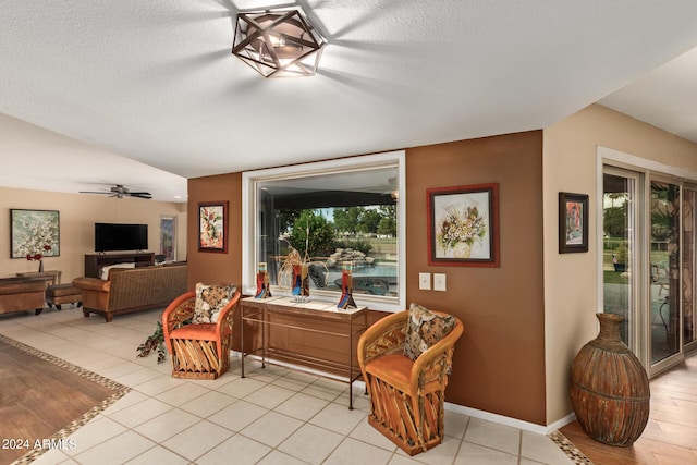 sitting room with light tile patterned flooring, a textured ceiling, a wealth of natural light, and ceiling fan