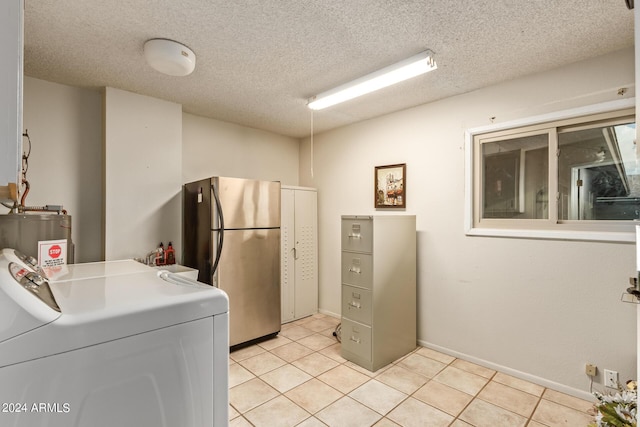 clothes washing area with gas water heater, light tile patterned floors, a textured ceiling, and washer / clothes dryer