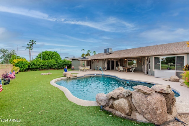 view of pool featuring a yard, a patio, and central AC unit