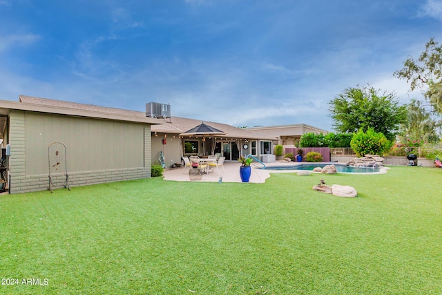 back of property with cooling unit, a fenced in pool, a yard, and a patio