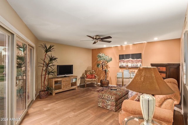 living room featuring light hardwood / wood-style flooring and ceiling fan