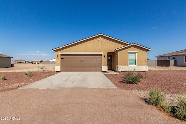 single story home with a garage, concrete driveway, and stucco siding