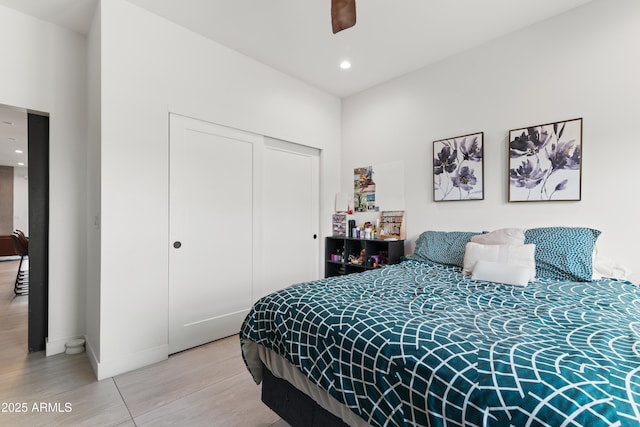 bedroom with ceiling fan, wood-type flooring, and a closet