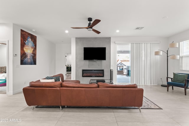 living room with a large fireplace and ceiling fan