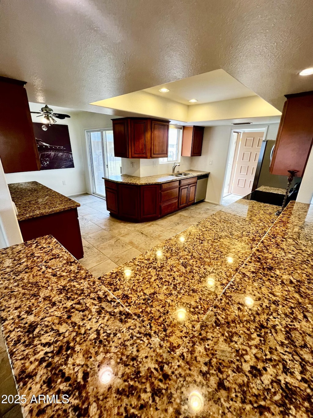 kitchen featuring a ceiling fan, recessed lighting, a sink, dark brown cabinets, and a textured ceiling