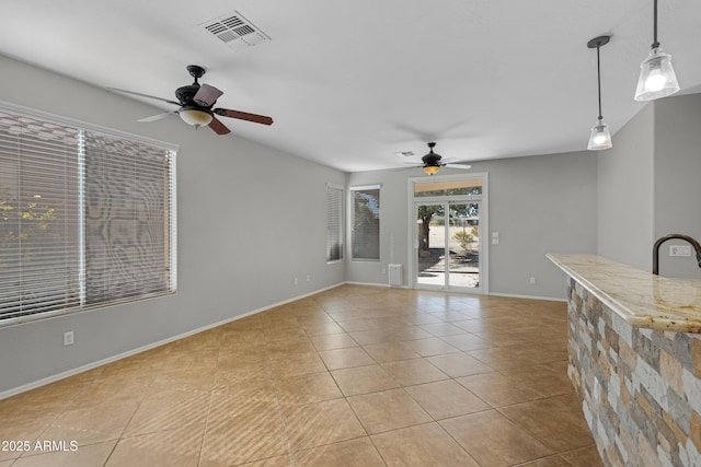 unfurnished living room with ceiling fan and light tile patterned floors