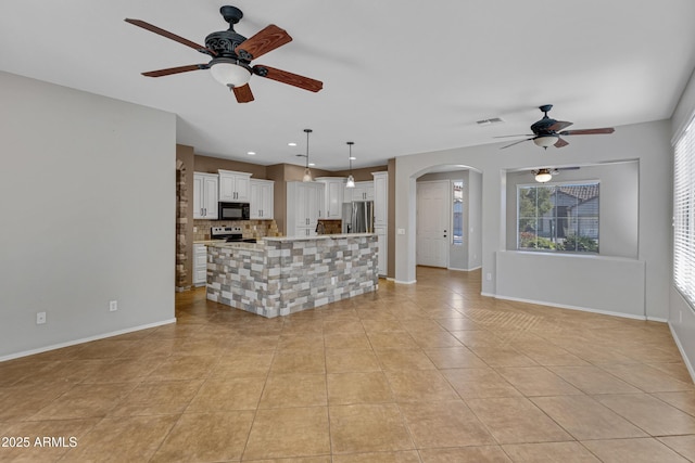 kitchen featuring stainless steel appliances, decorative light fixtures, a center island, and white cabinets