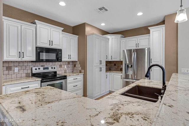 kitchen featuring pendant lighting, appliances with stainless steel finishes, sink, and white cabinets