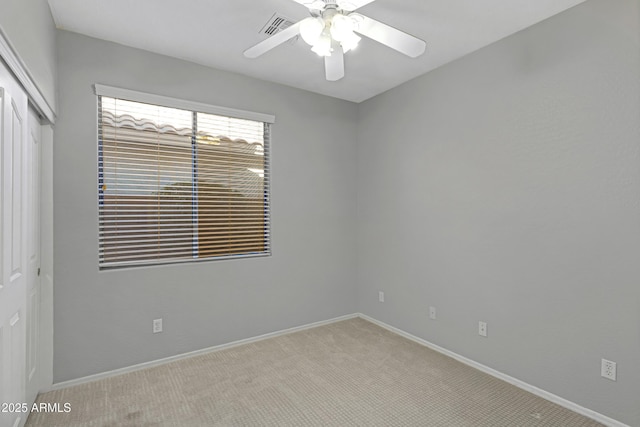 empty room with ceiling fan and light colored carpet