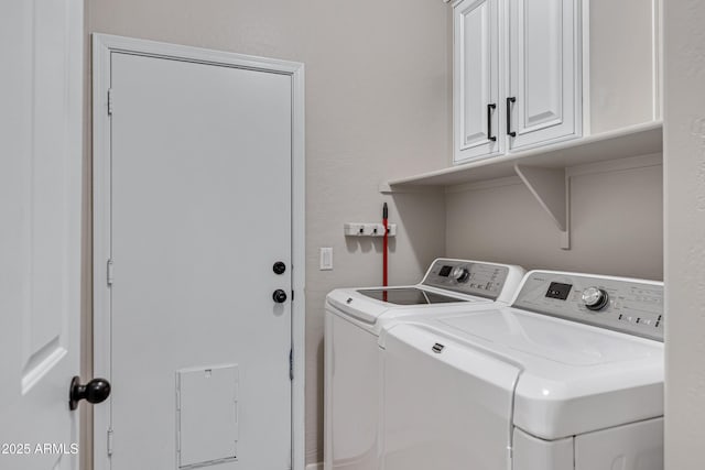 clothes washing area featuring washing machine and dryer and cabinets