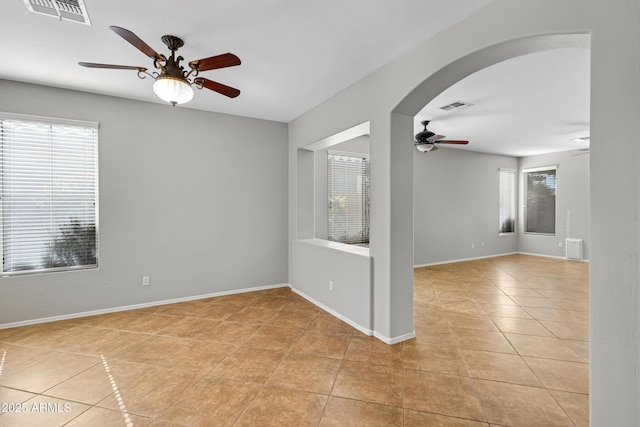 spare room with ceiling fan and light tile patterned floors