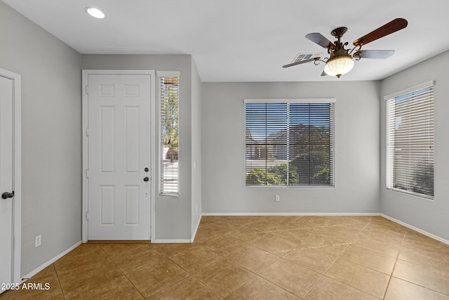 tiled entryway with plenty of natural light and ceiling fan