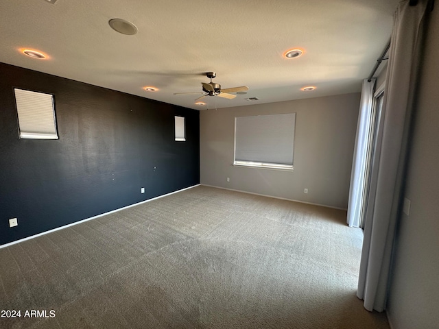 spare room with carpet floors, plenty of natural light, and ceiling fan