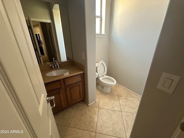 bathroom featuring vanity, tile patterned flooring, and toilet