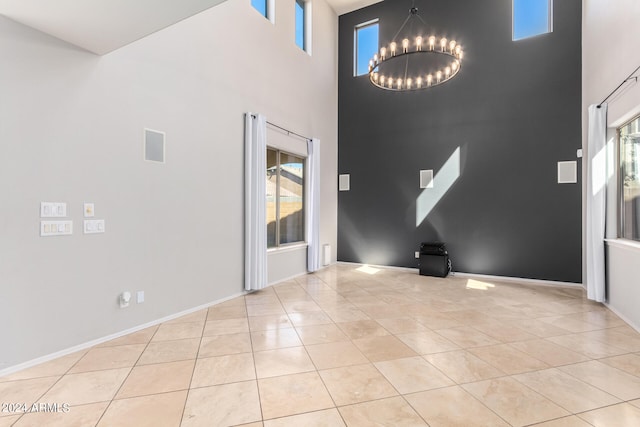 interior space featuring an inviting chandelier, a towering ceiling, and light tile patterned floors