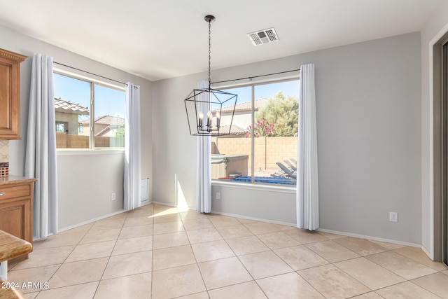 unfurnished dining area featuring light tile patterned floors, a chandelier, and a healthy amount of sunlight