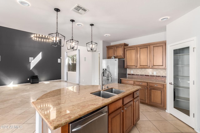 kitchen featuring light tile patterned flooring, sink, a center island with sink, appliances with stainless steel finishes, and light stone countertops