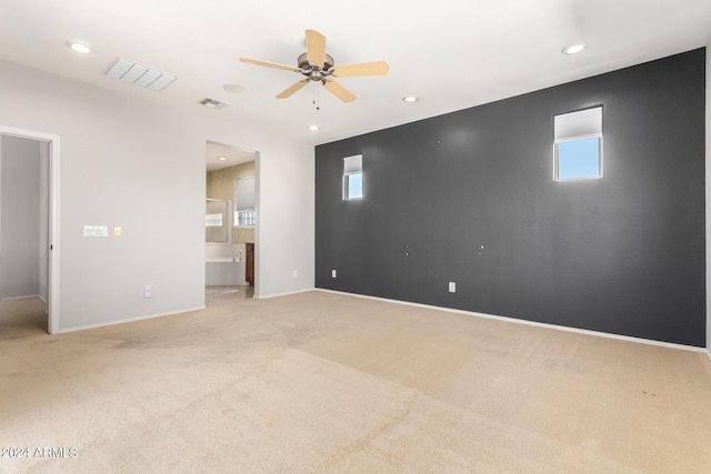 carpeted spare room featuring ceiling fan