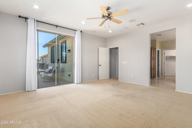 spare room featuring light colored carpet and ceiling fan