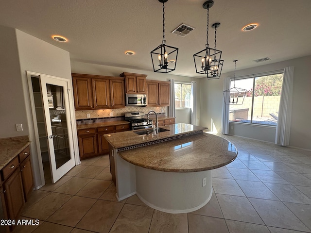 kitchen with stainless steel appliances, hanging light fixtures, tasteful backsplash, and sink