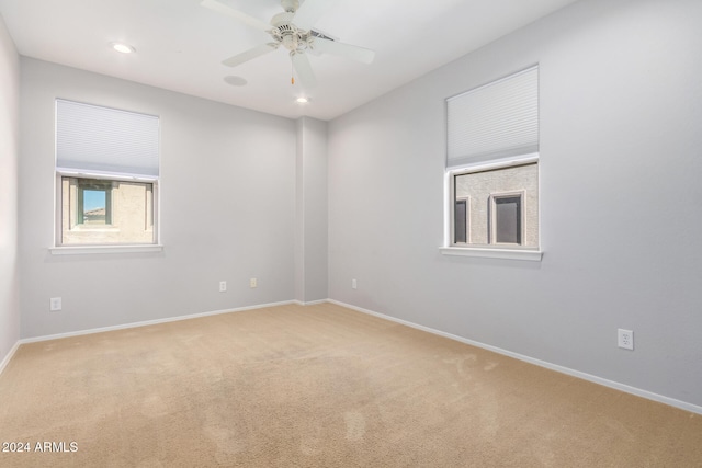 empty room with ceiling fan and light colored carpet