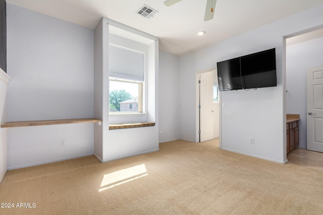 unfurnished bedroom with ceiling fan, light carpet, and ensuite bath