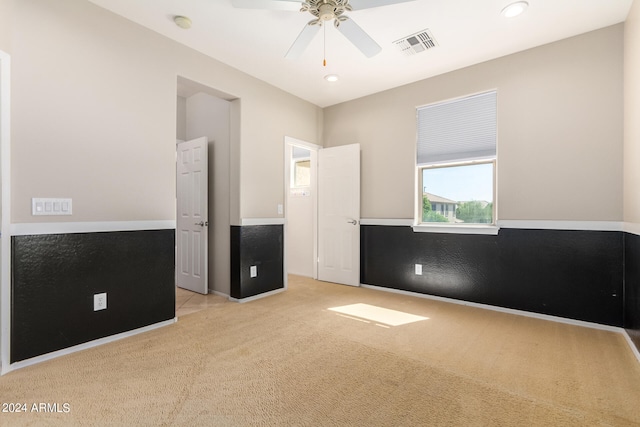 unfurnished bedroom with ceiling fan, light colored carpet, and golf simulator