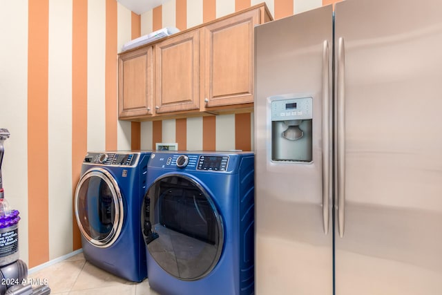 laundry area with light tile patterned flooring, independent washer and dryer, and cabinets