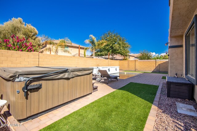 view of yard featuring a hot tub and a patio area