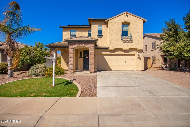 mediterranean / spanish-style house with a front yard and a garage