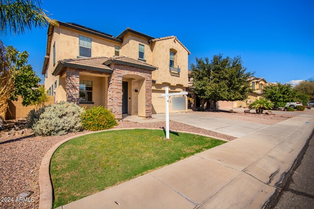 mediterranean / spanish-style house featuring a garage and a front lawn