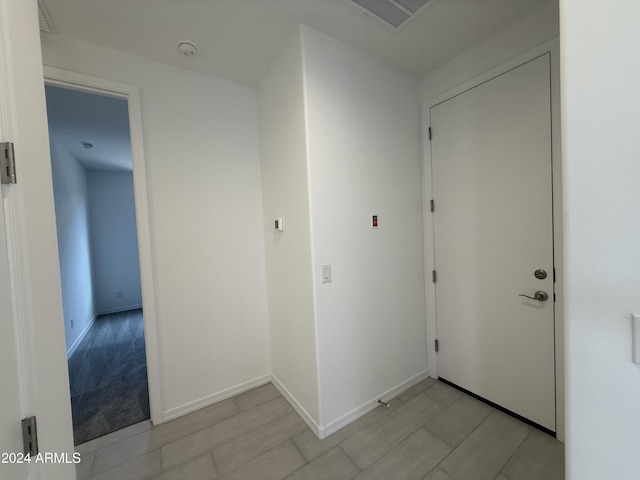 hallway featuring baseboards and visible vents