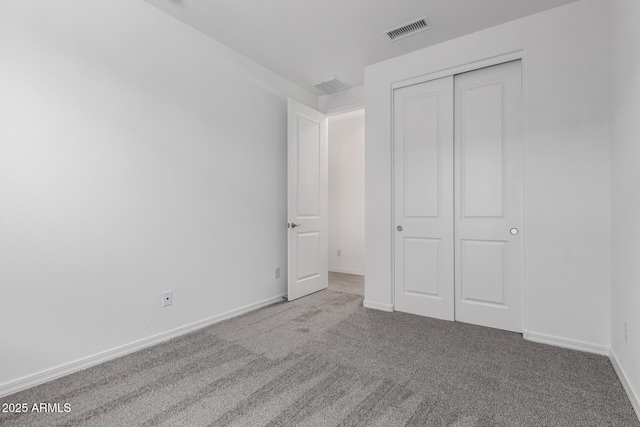 unfurnished bedroom with baseboards, visible vents, a closet, and carpet flooring