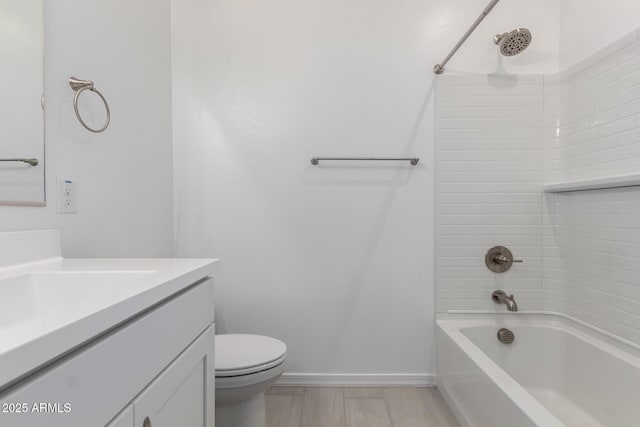 bathroom with bathtub / shower combination, toilet, baseboards, and vanity